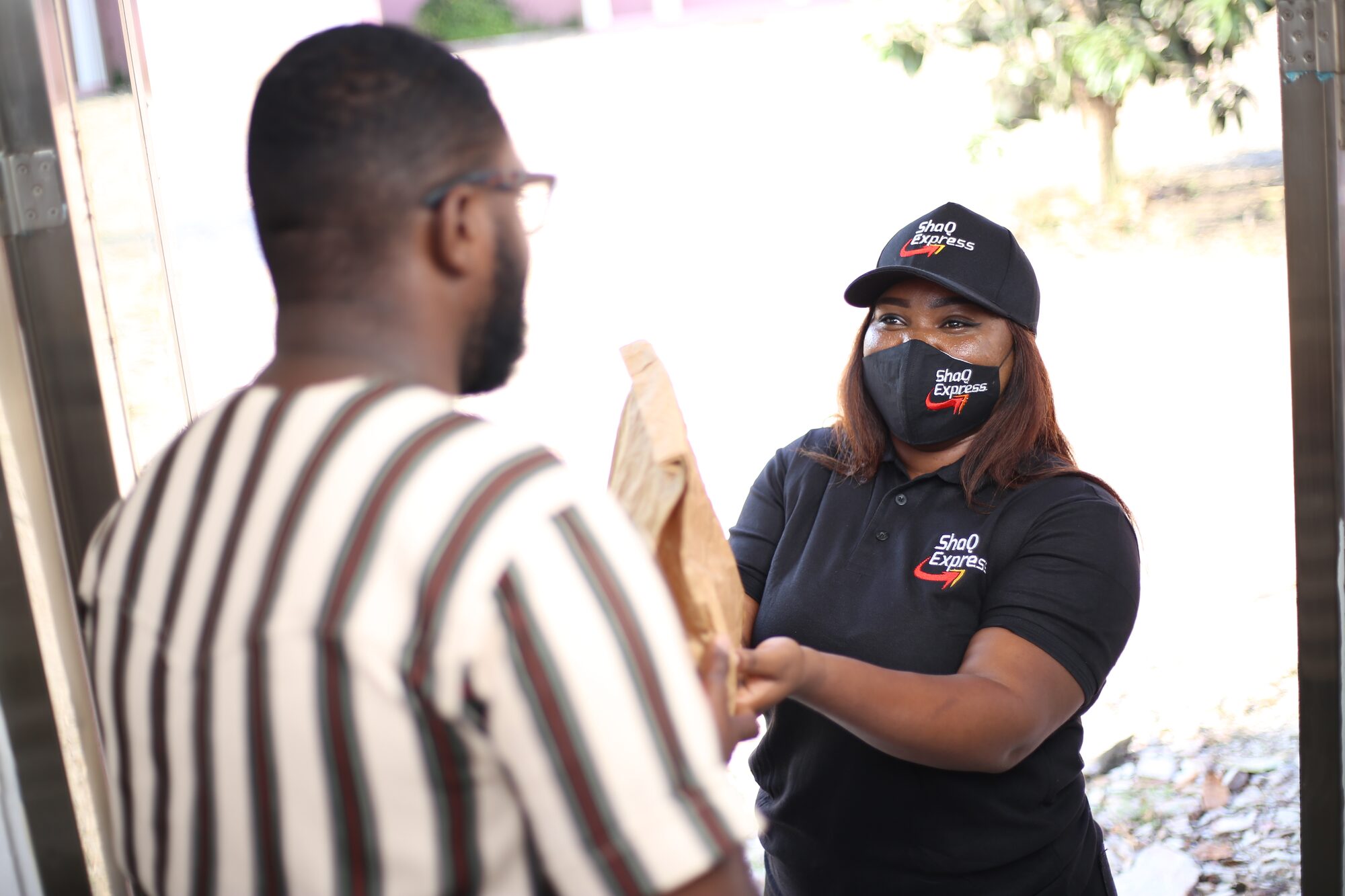 ShaQ Express courier handing a parcel to a customer at the door